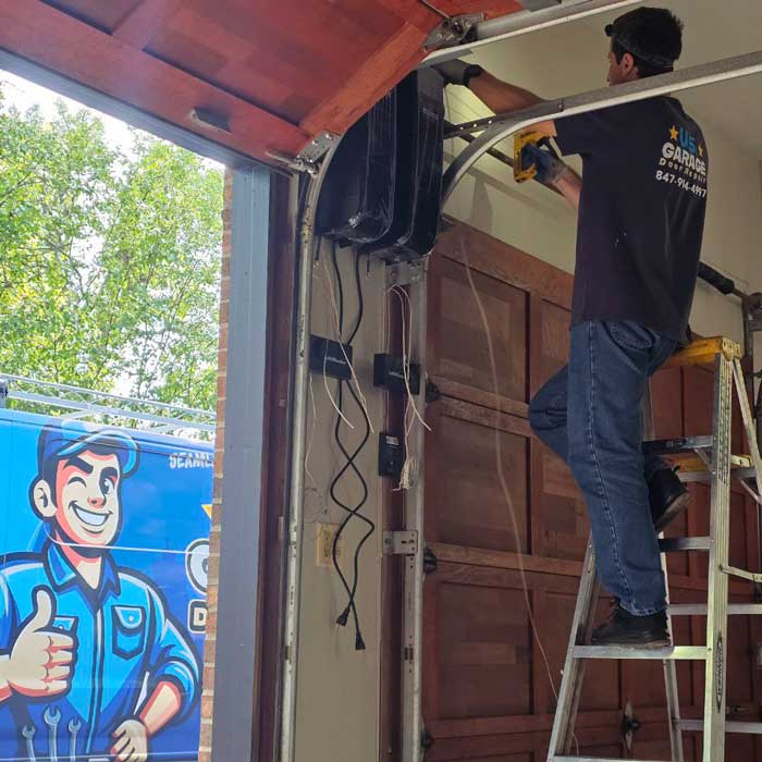 A US Garage Door technician fixing garage door cables near Des Plaines IL